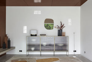 Calot — lampa przy komodzie z frontami szklanymi, ujęcie lifestyle w nowoczesnym pokoju