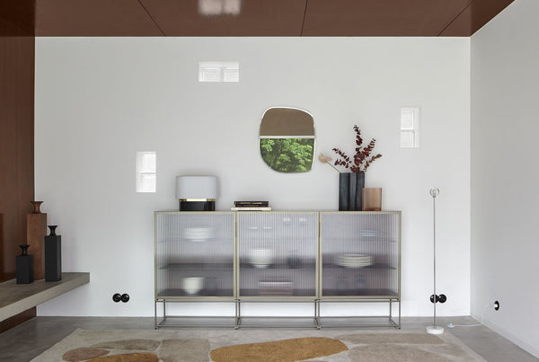 Calot — lampa przy komodzie z frontami szklanymi, ujęcie lifestyle w nowoczesnym pokoju
