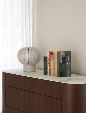 Eki — lampa na komodzie w minimalistycznym wnętrzu, obok książek, naturalne światło
