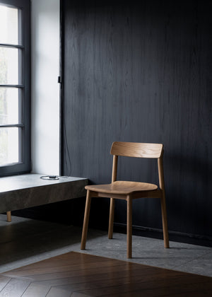 Arche — w aranżacji minimalistycznego wnętrza, przy biurku z czarną ścianą