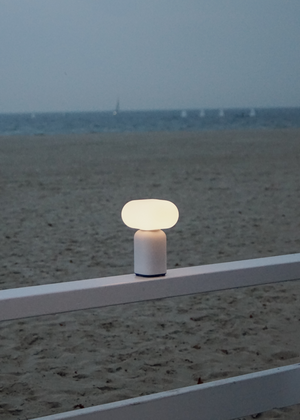 Velis — oświetlona lampa na plaży, ujęcie lifestyle nad piaskiem i morzem