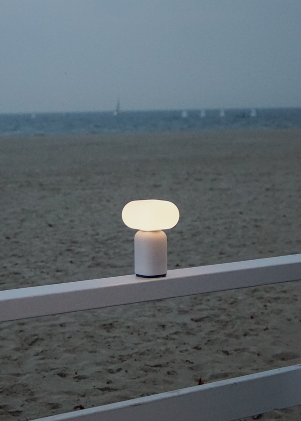Velis — oświetlona lampa na plaży, ujęcie lifestyle nad piaskiem i morzem