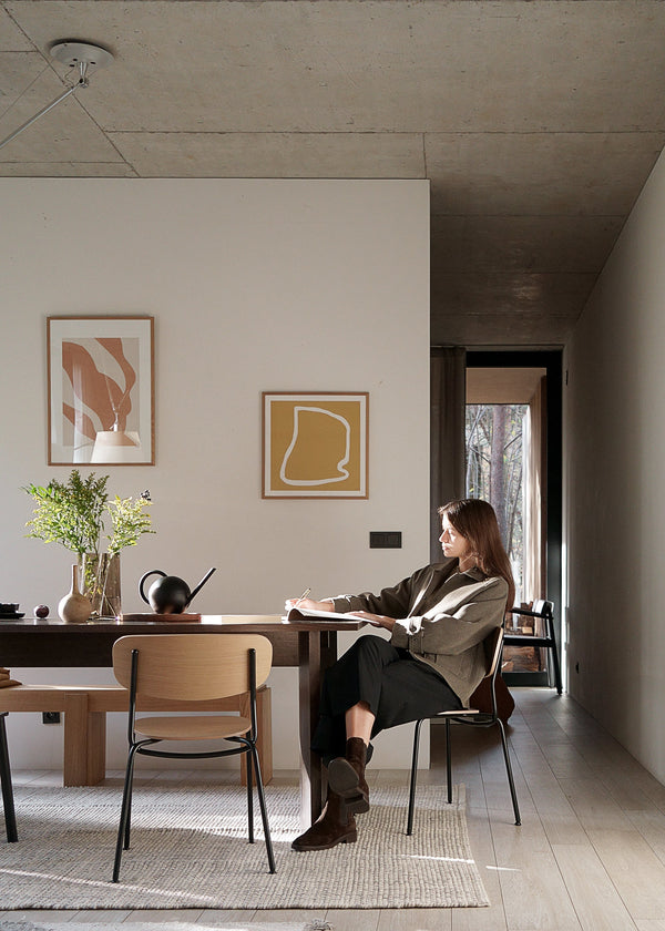 Splot — kobieta siedząca na krześle, ujęcie lifestyle w minimalistycznym wnętrzu
