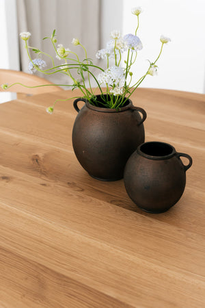 Sol — doniczki ceramiczne na blacie, zbliżenie na teksturę drewna
