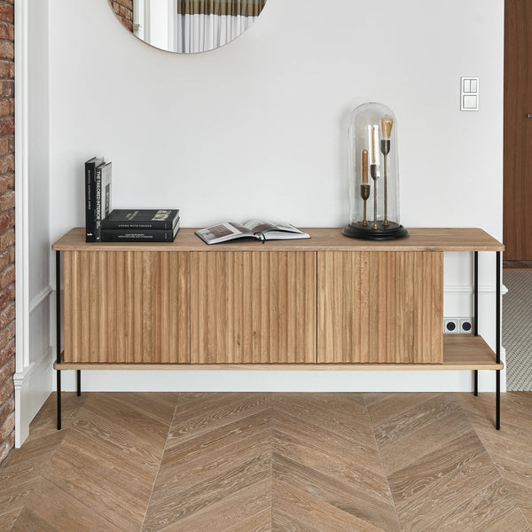 Maya 3 — komoda w wnętrzu z cegłą, półki otwarte, drewniany front z żebrami, ujęcie lifestyle